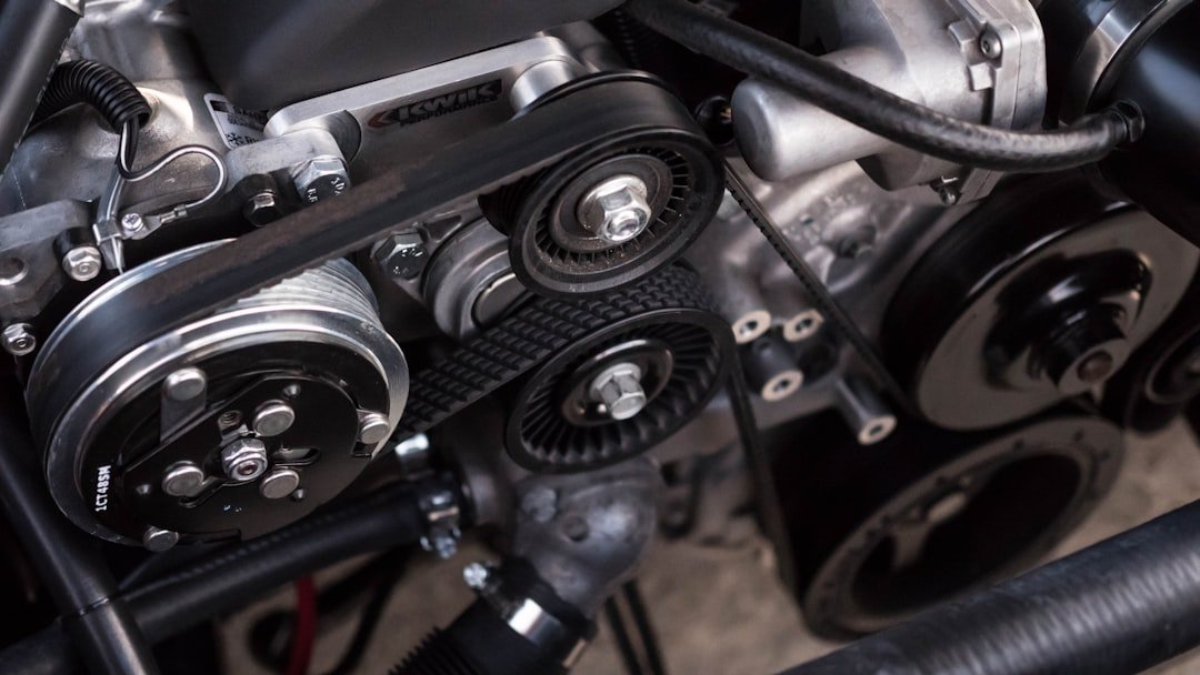Mechanic replacing serpentine belt on vehicle engine