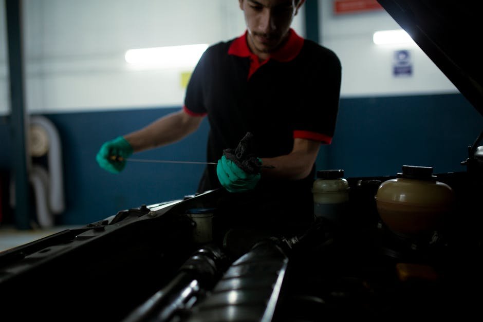 Mechanic checking engine oil level on Toyota